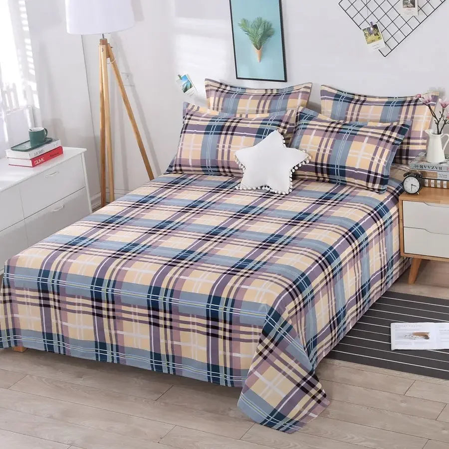 Plaid bedspread set on a bed in a bedroom with nightstands and decor.