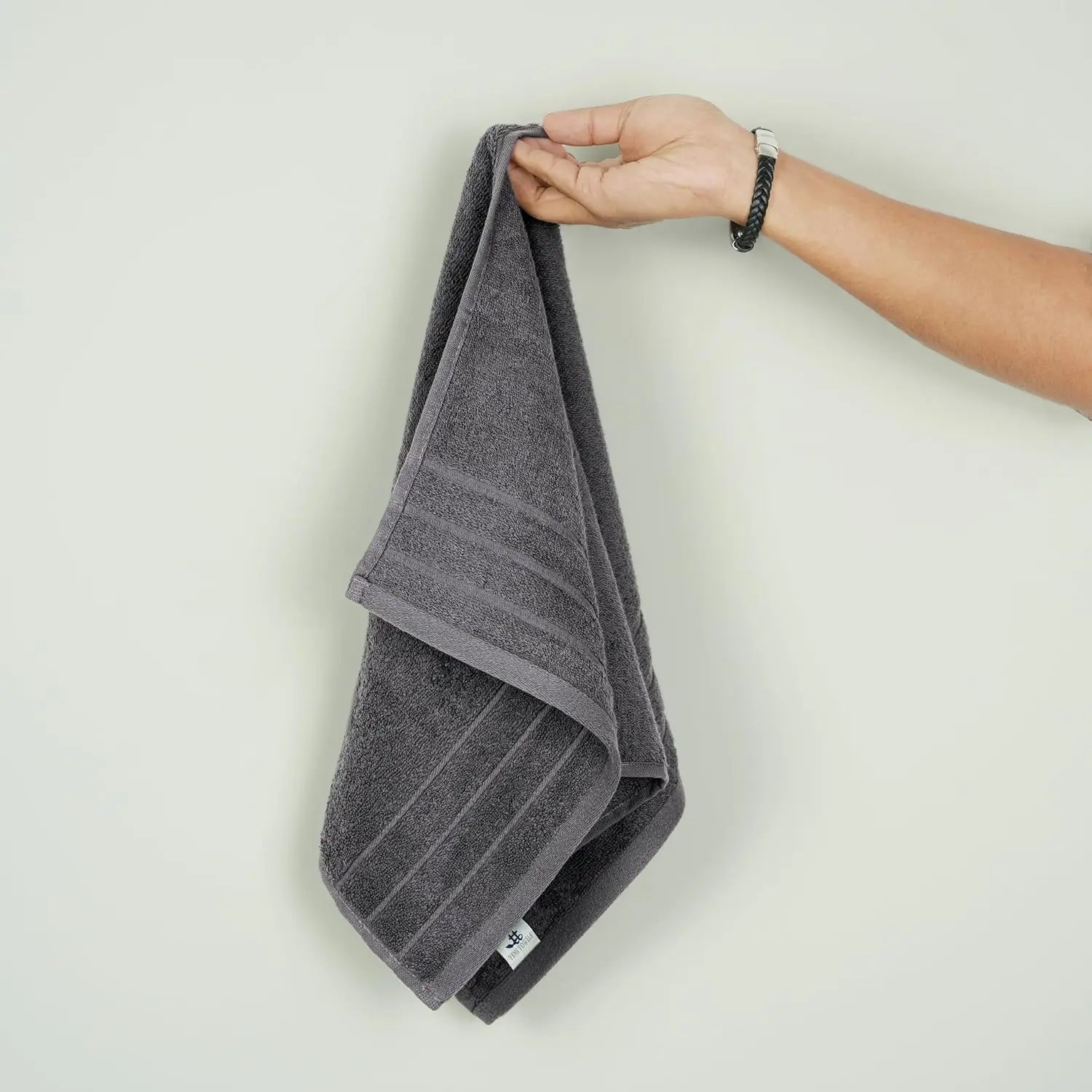 Person holding a gray towel against a light background