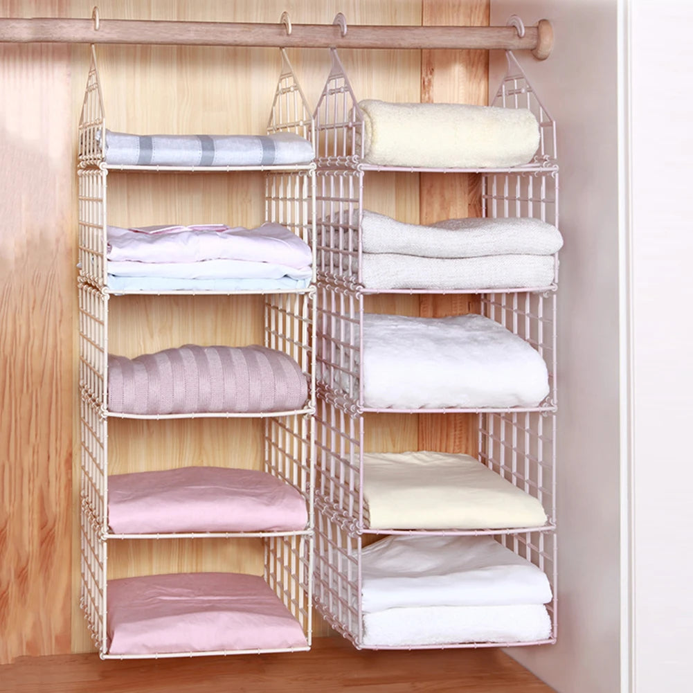 Clothing organizer with folded clothes on a wooden floor against a wooden wall.