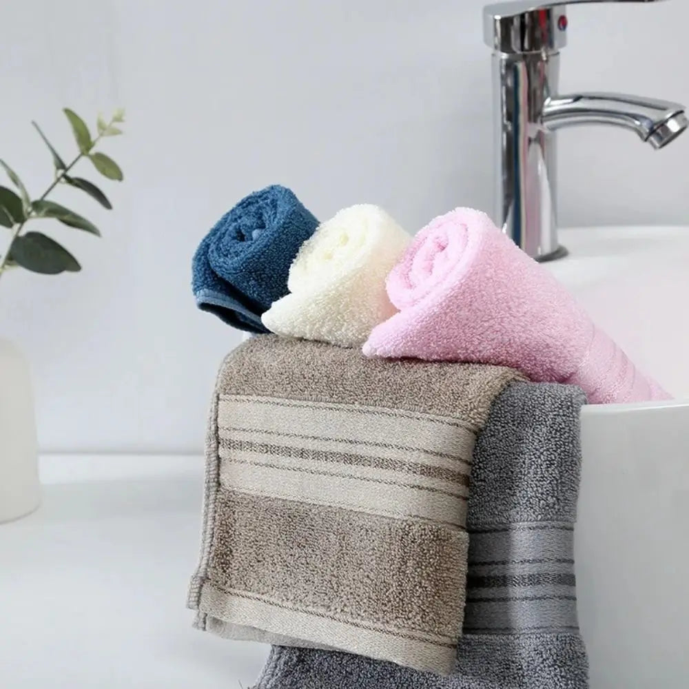 Stack of colorful towels on a towel rack with a sink and faucet in the background.