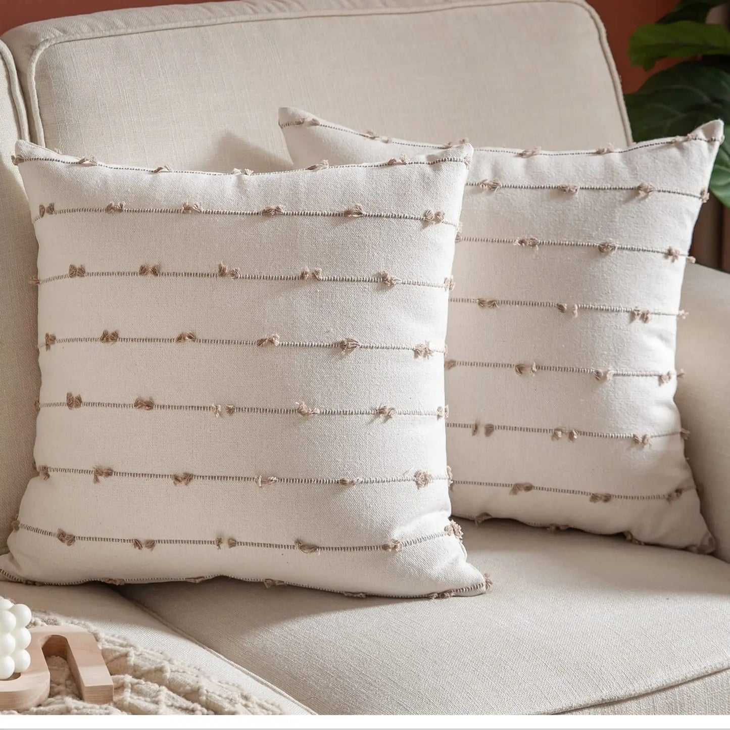 Two decorative pillows with a textured pattern on a beige sofa.