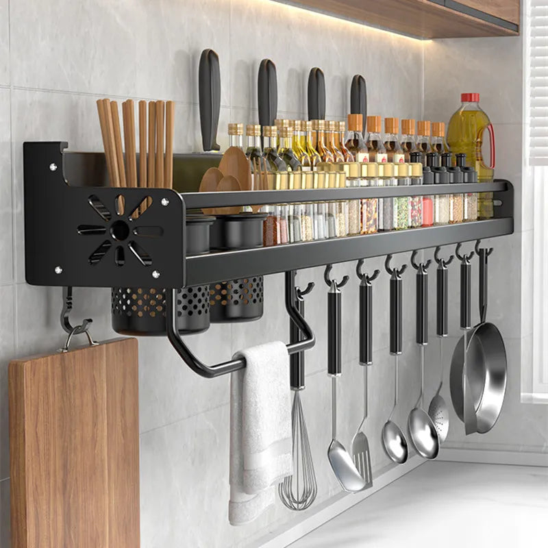 Kitchen utensil rack with various tools and containers on a tiled wall.