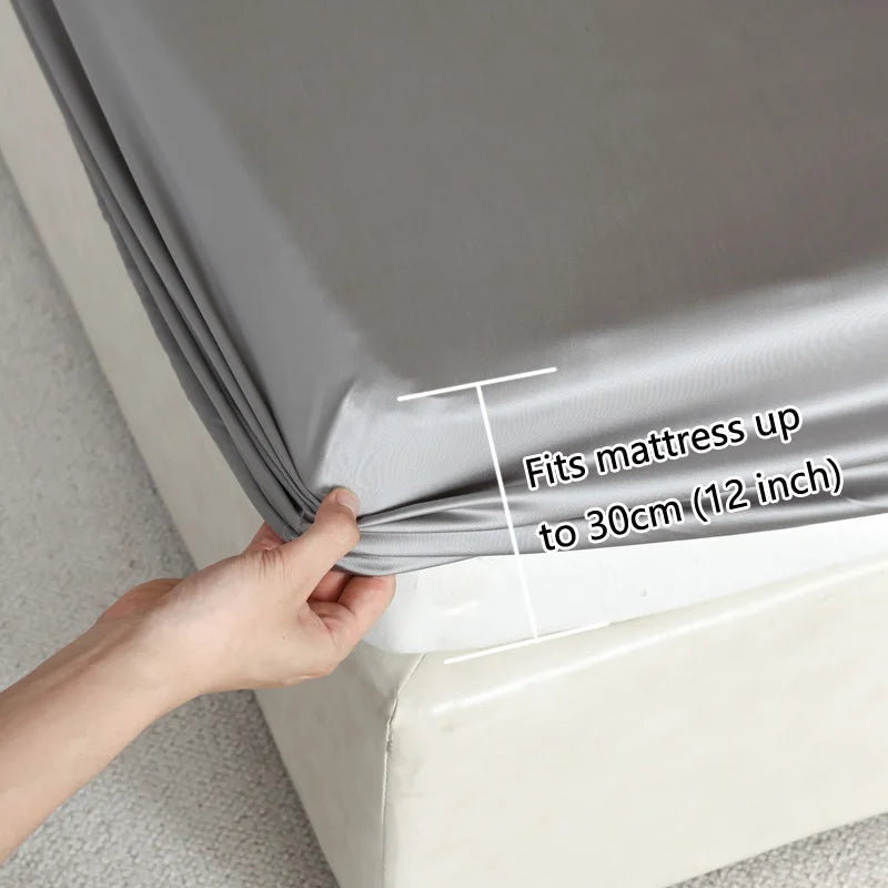 Person holding a roll of gray mattress cover with text indicating it fits mattresses up to 30cm.