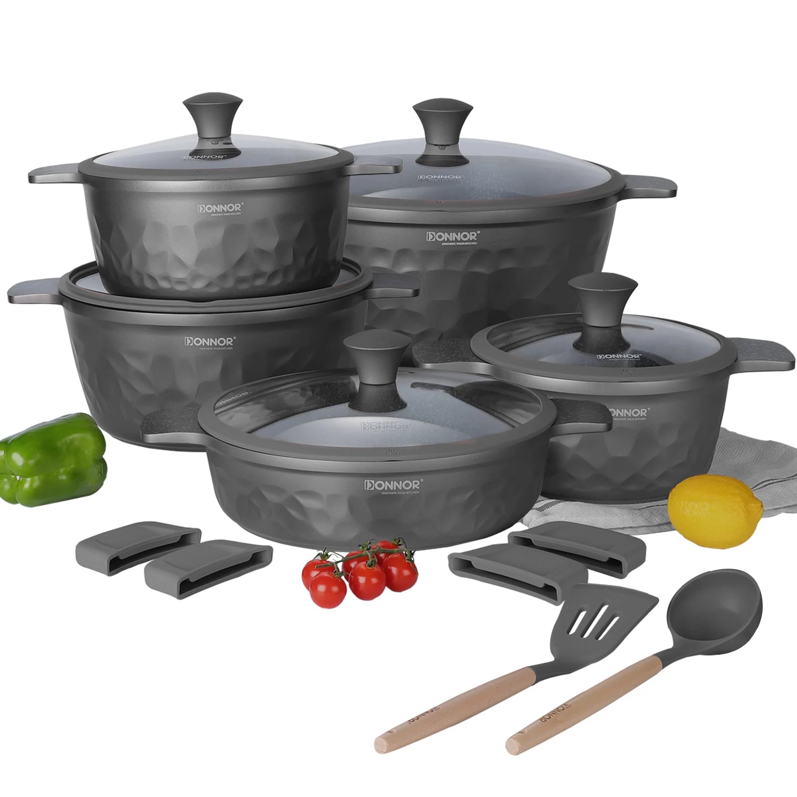 Set of gray cookware with lids, utensils, and vegetables on a white background