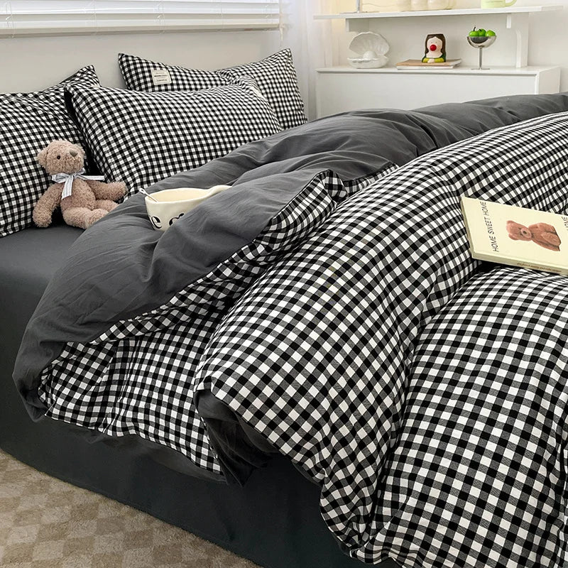 Bed with black and white checkered bedding and gray comforter
