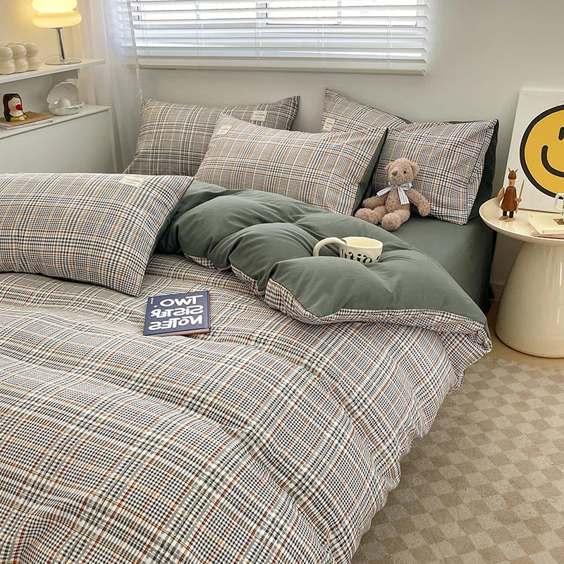 Bed with plaid bedding and pillows, teddy bear, and books in a room.