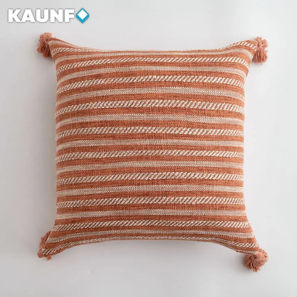 Striped pillow with tassels on a white background, featuring the brand 'KAUNF'.