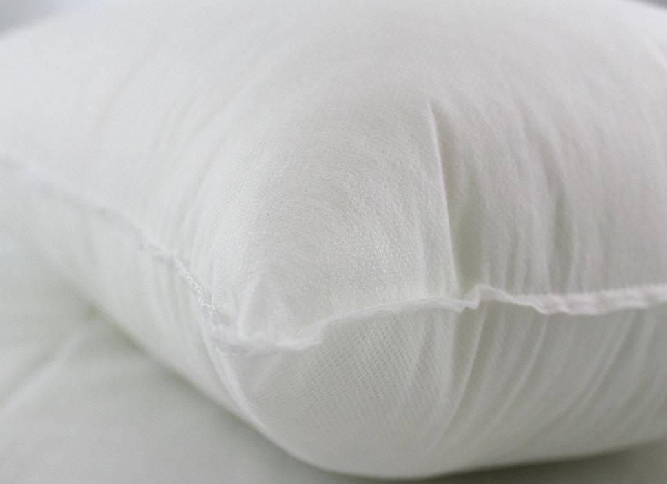 Close-up of a white pillow on a light gray background