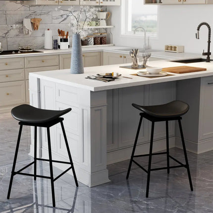 Modern kitchen with a white island, black bar stools, and various kitchen items.