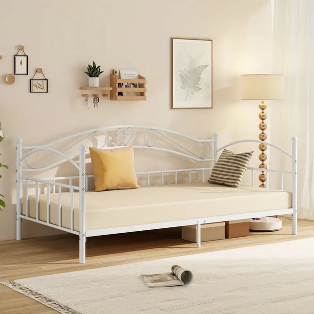 White metal daybed with cushions in a room setting with decor elements.