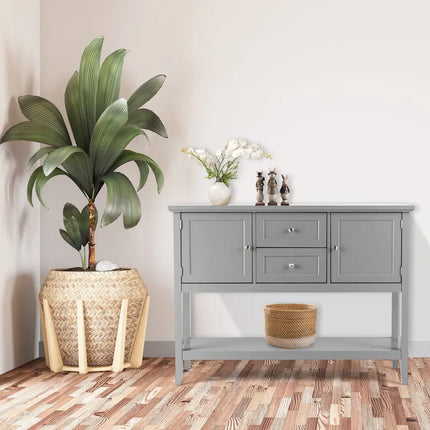 Gray sideboard with decorative items and a plant on a wooden floor.